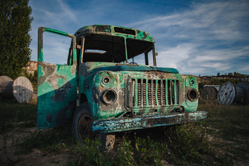 old abandoned bus green in the field