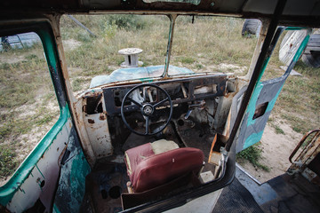 horizontal image of the inside of the front of a very old broken down bus