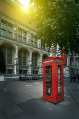 Famous red phone booth in London in the morning sun light. Movie poster concept. Toned - 288160404