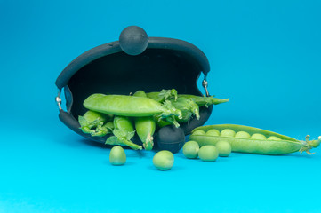 Pea pods and peas spilling from frame purse