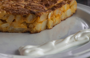 Spanish omelet with mayonnaise, on a white plate