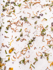 Shredded dried leaves and petals of herbs on a white tablecloth