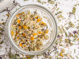 Shredded dried chamomile in a glass jar. Closeup view
