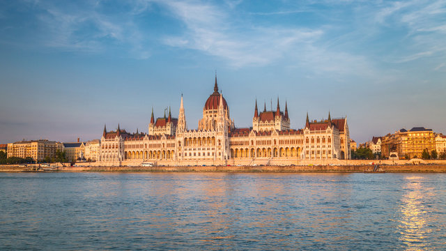 The Hungarian Parliament Building, a notable landmark of Hungary in Budapest. View of the main facade above the Danube river at a sunset.