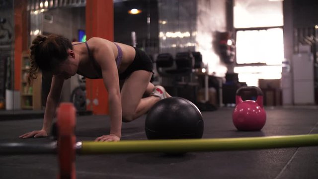 Asian female athlete pushing body limits by doing mountaineering run exhausted Chinese woman kneeling with her hands on ground try to catch breath then set up waist After exercise in Gym