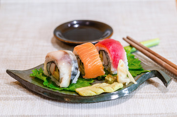 Sushi roll with salmon, Tuna on leaf dish.