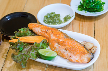 Grilled salmon with vegetables served.