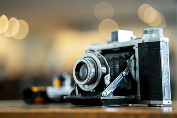 Fototapeta na wymiar Retro film photo camera isolated on blurred background at light bokeh..