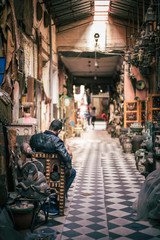Obraz premium Vendeur attendant des client dans une échoppe des Souks de Marrakech, Maroc