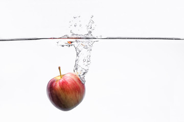 Water splashing with red apple on white background. fresh, healthy concept