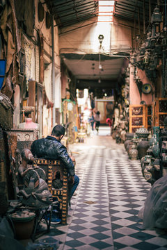 Vendeur attendant des client dans une échoppe des Souks de Marrakech, Maroc