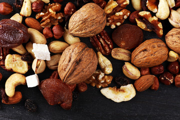 Composition with dried fruits and assorted healthy nuts on rustic background