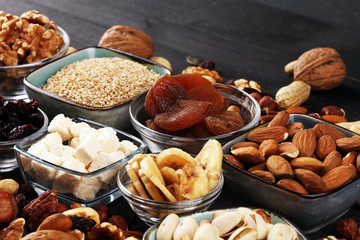 Composition with dried fruits and assorted healthy nuts on rustic background