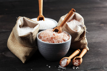 Sea salt and himalayan in burlap. Crystals of salt on dark background