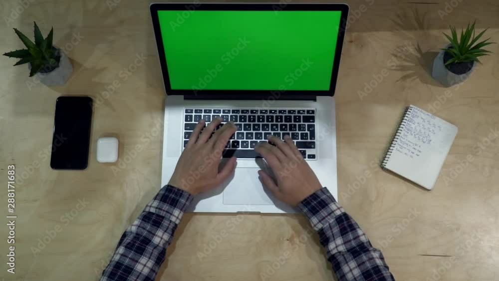 Poster close-up. top view. man using laptop computer on office table background. green screen. chroma key. 