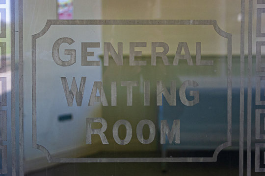 An etched glass Waiting Room sign
