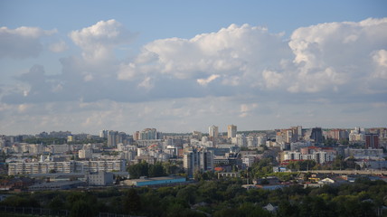 Naklejka premium panoramic top view of tall houses against the sky with white clouds