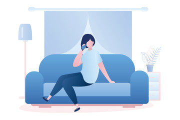 A woman is sitting on the couch and talking on the phone, living room interior.