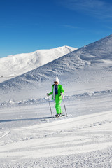 Fototapeta na wymiar Skier on snowy ski slope at nice sun day