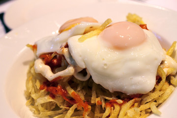 uovo all'occhio di bue  incavolato su patate fritte e salsa piccante
