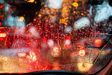 Traffic Jam with raining in evening day , focus on the rain drop of car window.