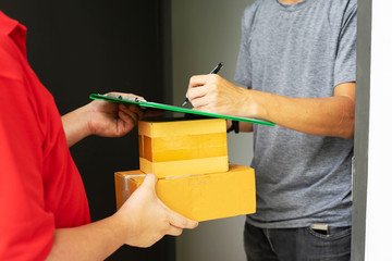 Postman delivering package of goods to home. Selective focus on the hands. Home delivery concept, Deliver packages to recipients quickly, complete products, impressive services.