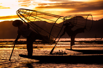 Burmese Fishermen posing with conical nets at sunset, Inle Lake in the Nyaungshwe Township part of...