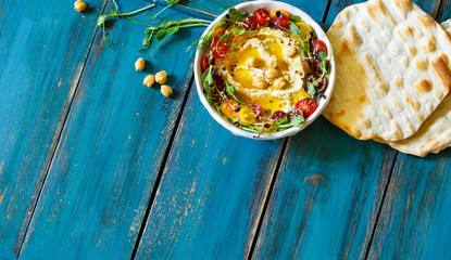 Hummus with olive oil, sprouts and tomatoes