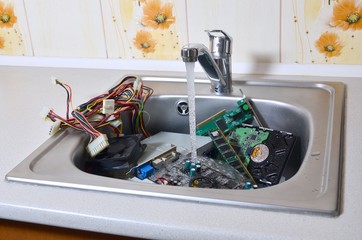 Hardware in kitchen sink under the water flow computer cleaning metaphoric concept