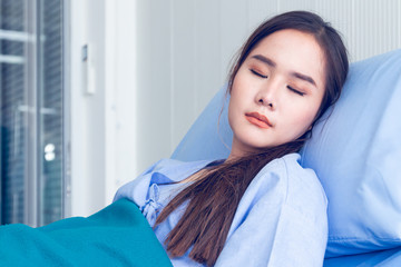 Asian young female patients wearing blue shirts lying in the bed with a bright face Have better...
