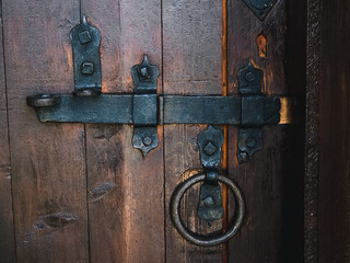old black metal deadbolt on a wooden door close-up