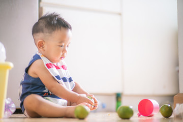 Fototapeta premium Adorable baby boy enjoying with fruit toy