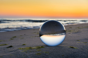 Szklana kula na brzegu morza. Piękny wschód słońca