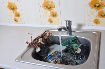 Hardware in kitchen sink under the water flow computer cleaning metaphoric concept