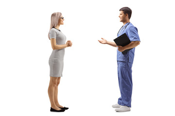 Young male doctor in a blue uniform talking to a young woman
