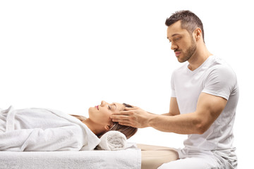 Professional masseur giving a head massage to a young woman