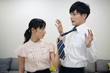 ネクタイをつかんで夫に詰め寄る妻