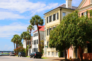 Fototapeta na wymiar Street view with beautiful buildings, palm trees and parked cars in the historic downtown area city of Charleston, South Carolina, USA. Southern style architecture background.