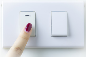 Close up of finger is turning on or off on light switch,fingers are turning off light switch in the house,Concept : Save Energy, Save World, Save money, Selective focus.