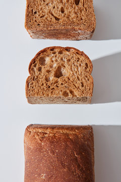 Dark buckwheat bread cut on a gray background with a pattern of shadows and copy space. Organic food