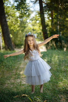 Girl in dress playing in forest