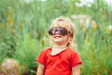 little girl in sunglasses smiling