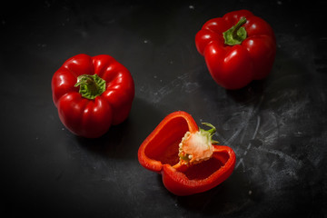 Three ripe sweet bell peppers on a black background