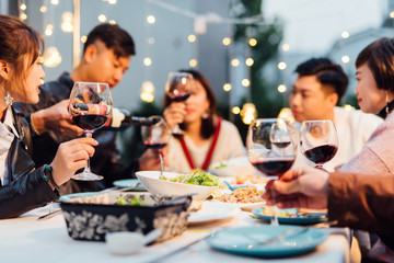 Group of friends having dinner together in a backyard