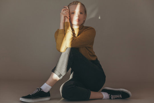 Young human in casual wear sitting in light room