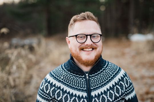 portrait of handsome redhead man wearing Christmas sweater
