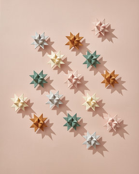 Origami stars presented in the form of a pattern on a beige background with a copy of the space. Christmas card. Flat lay