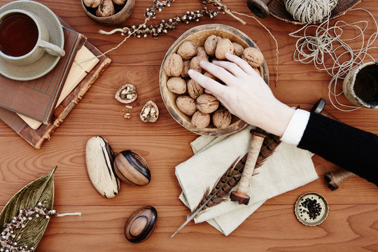 Woman's hand picking up walnuts on table
