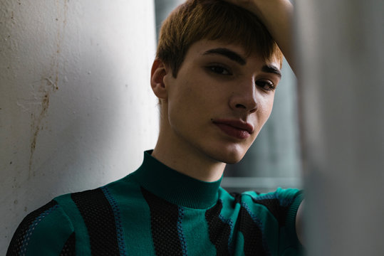 Young confident androgyne man in striped shirt