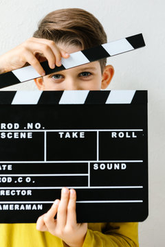 Little boy holding clapper board in hands